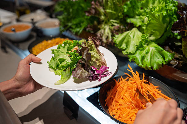 istock A Woman Selecting Fresh Lettuce at Salad Bar 2244338022