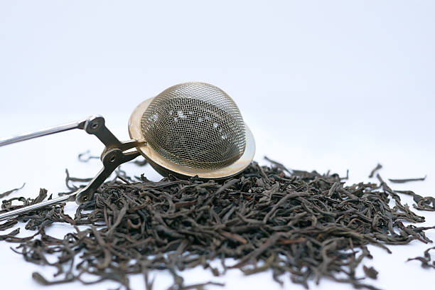 Loose Leaf Black Tea with Metal Tea Infuser on White Background