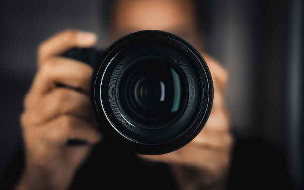 istock Photographer Holding Camera with Focus on Lens 2244340593