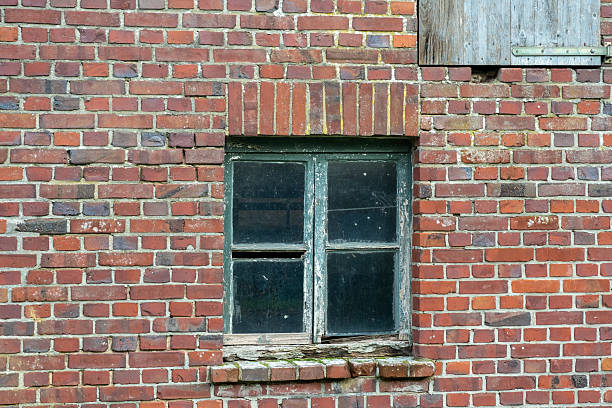 istock Old brick wall with a weathered window showcasing rustic charm in a rural setting 2244341064
