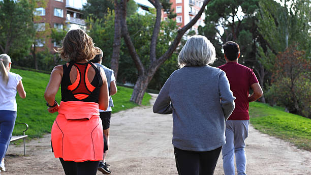 istock Group of people running through park trail 2244343726