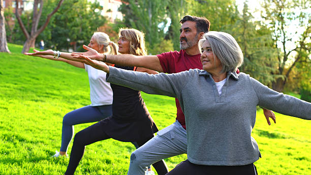 istock Seniors doing yoga outdoors in city park 2244343779