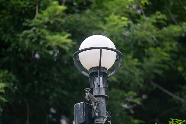 A stunning street lamp stands gracefully against a lush green backdrop, highlighting the beauty of urban design combined with nature's tranquility.