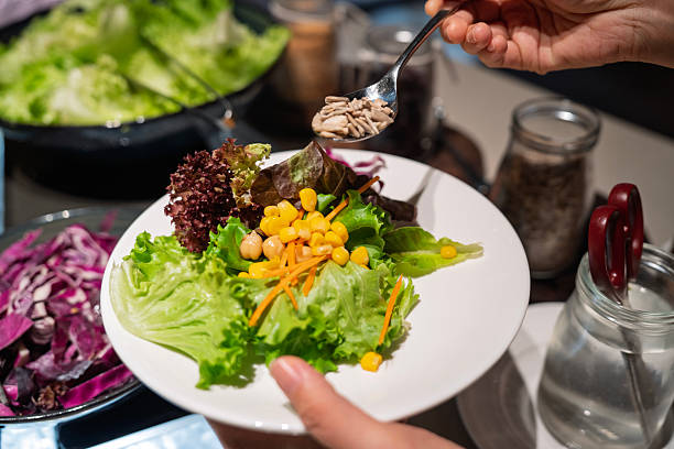 istock A Woman Selecting Fresh Lettuce at Salad Bar 2244345779