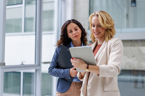 istock Businesswomen collaborating on digital tablet in modern office 2244345789