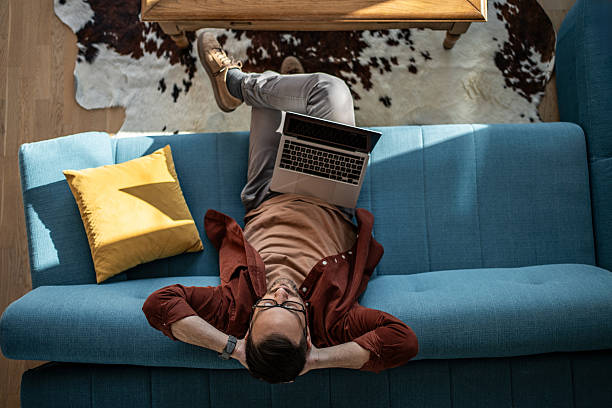 istock Man relaxing on sofa working with laptop at home 2244346979