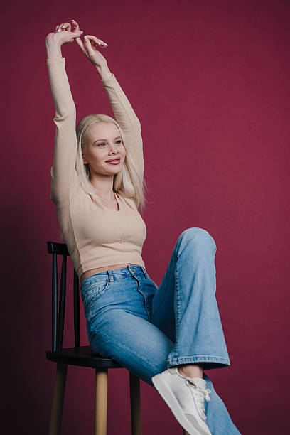 istock Model in beige top and denim shorts extending arms in studio 2244347336