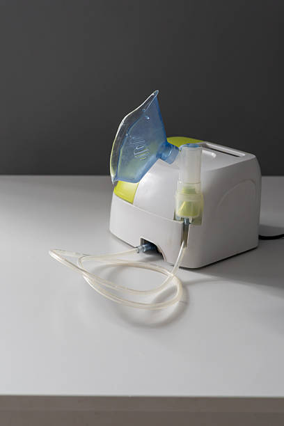 istock A nebulizer sits on a white table, connected with a clear tube to a mask. The device is designed for respiratory therapy in a peaceful indoor setting 2244347477