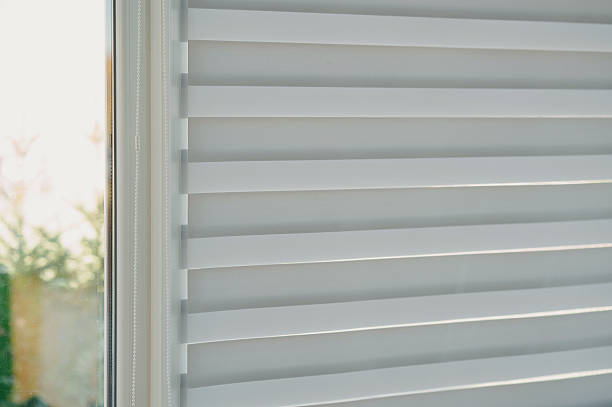 istock natural light filters through blinds, quiet morning scene with sunlight through window coverings 2244351875