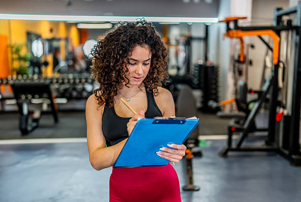 istock Woman personal trainer planning workout in gym 2244352205