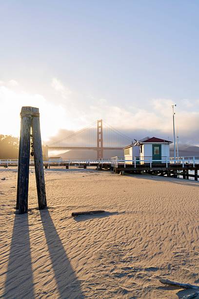 Bell with warning light and sailboats next to the Golden Gate Bridge in San Francisco Bay, California, United States.