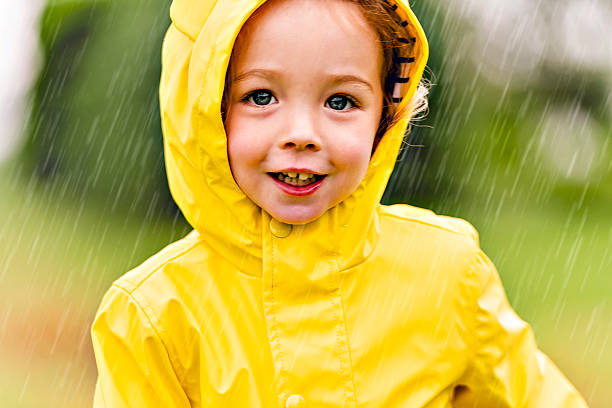 istock Happy funny child with raincoat under the summer raining day 2244354673