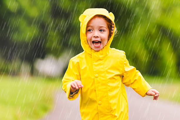 istock Happy funny child with raincoat under the summer raining day 2244354676