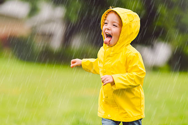 istock Happy funny child with raincoat under the summer raining day 2244354686