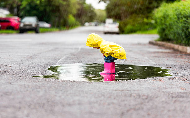 istock Happy funny child with raincoat under the summer raining day 2244354712