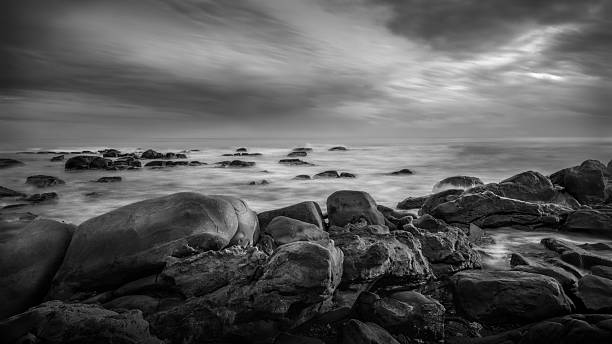 istock Dramatic Black and White Seascape with Rocky Shore and Cloudy Sky 2244356374
