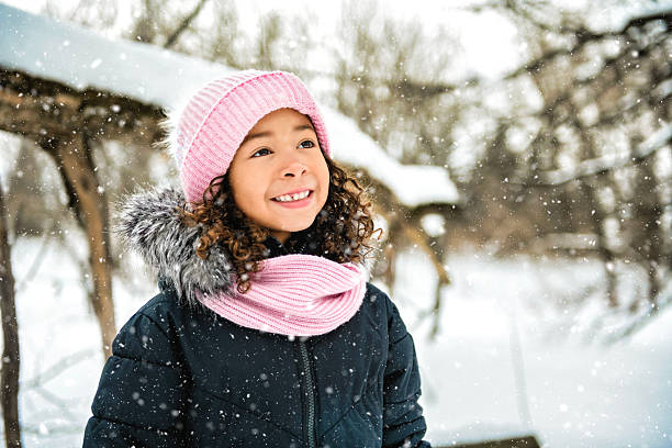 istock smiling american child during snowfall in winter park 2244356558