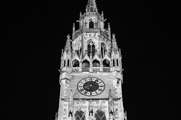 Munich, Germany - January 01, 2015 - Gothic clock tower illuminated at night with ornate architecture details.