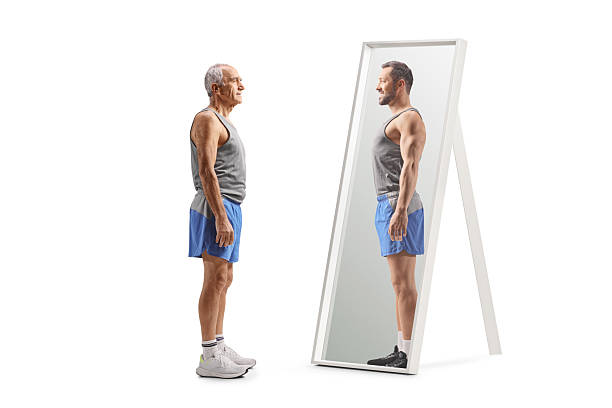 istock Elderly man seeing his younger self in a mirror 2244358631