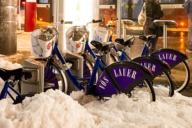 Salzburg, Austria - January 03, 2015 - Bicycles parked in snowy urban setting at night.