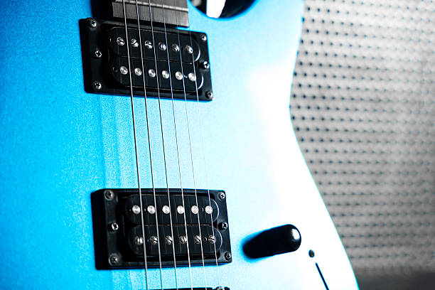 Blue Electric guitar with amplifier on light blue background. Music instruments with copy space for text or advertising design.