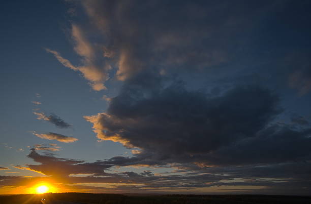 Russia, south of Western Siberia. Panoramic view of the evening sky with the setting sun and colorful clouds.