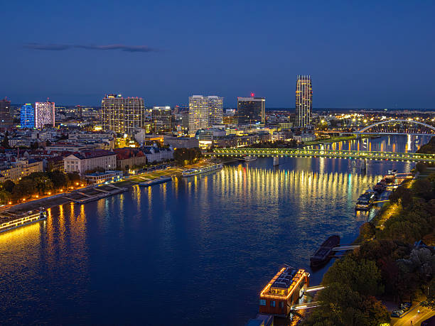 Bratislava, Slovakia - October 18, 2025: Night view of a Bratislava city skyline with illuminated buildings and a Danube river reflecting lights.