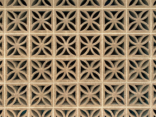 istock A repeating geometric pattern of concrete blocks with flowerlike cutout shapes forms a decorative wall in a grid arrangement with textured surfaces and open spaces throughout 2244368435