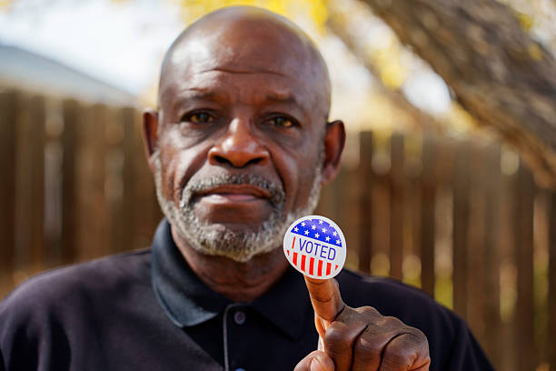 istock Senior man holding “I Voted” sticker in yard 2244369155