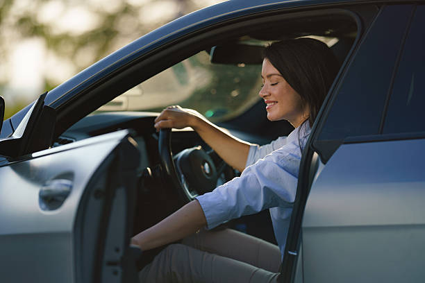 istock Woman smiling getting into car for driving journey. 2244369291