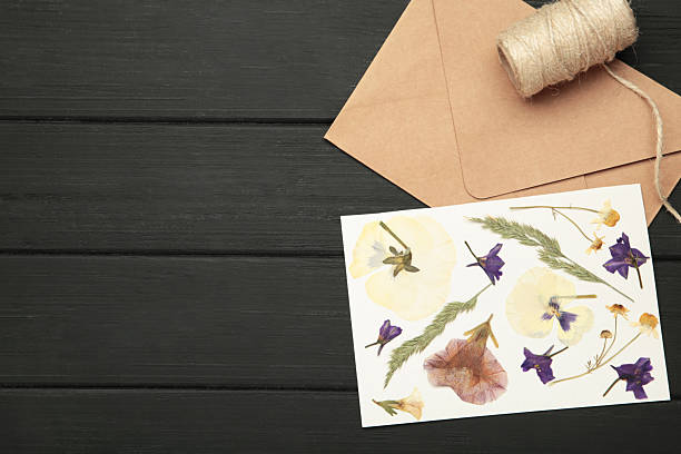 istock Flat lay composition with beautiful dried flowers and envelope on black wooden background 2244369365