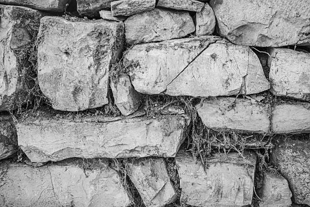 Black and white close-up of an old stone wall with rough texture