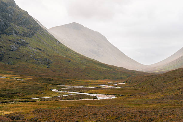 River flowing through the moody glencoe valley landscape in the scottish highlands