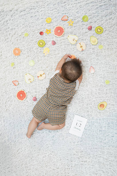 istock A baby laying on a white rug with a card that says 