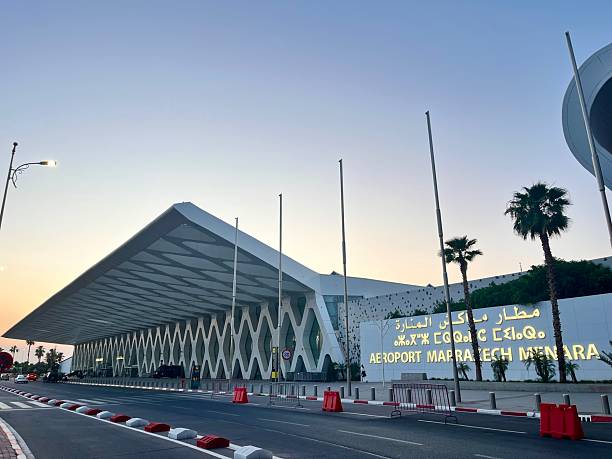 Marrakech, Morocco - June 3, 2025: Marrakech Menara Airport terminal building entrance at dusk, featuring modern architecture, palm trees, and the airport name sign, representing travel and tourism in Morocco
