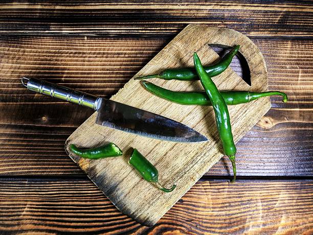 istock Fresh green chili peppers on a rustic wooden cutting board. 2244390254