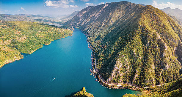 istock Aerial view showing Drina River winding through a deep canyon, surrounded by green mountains and floating houses 2244392883