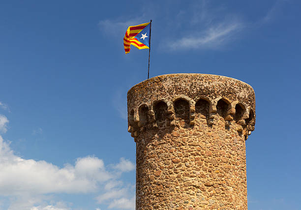 Historic round stone tower with Catalonia flag in Tossa de Mar Spain