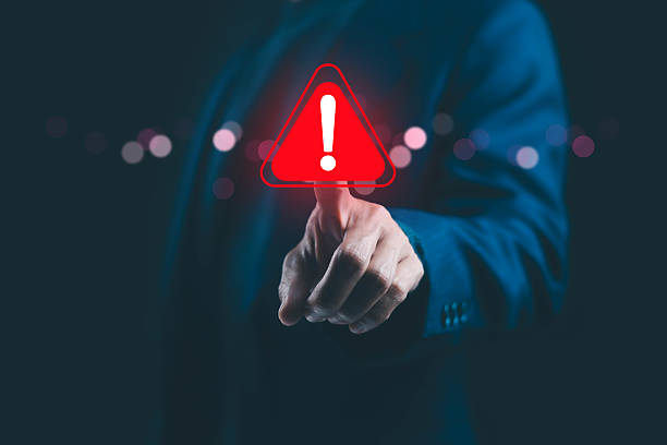 istock A businessman touching a glowing red warning icon with an exclamation mark, symbolizing cybersecurity alert, data breach risk, and digital system failure in modern technology and business. 2244395554
