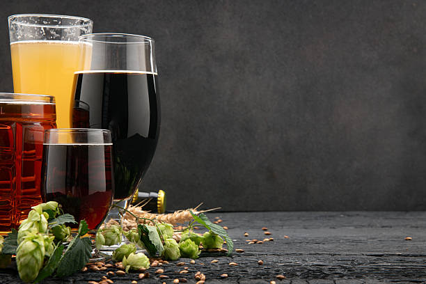 istock Craft beer glasses with hops and malt on dark background 2244396041