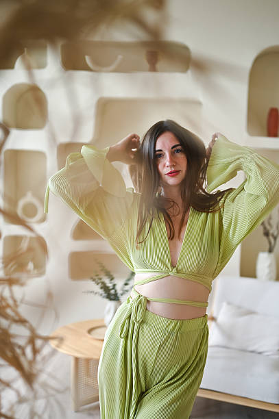 istock Stylish woman posing in green boho outfit at home 2244398521