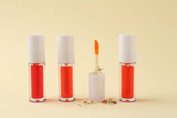 istock Bright lip glosses and applicator on beige background 2244398617