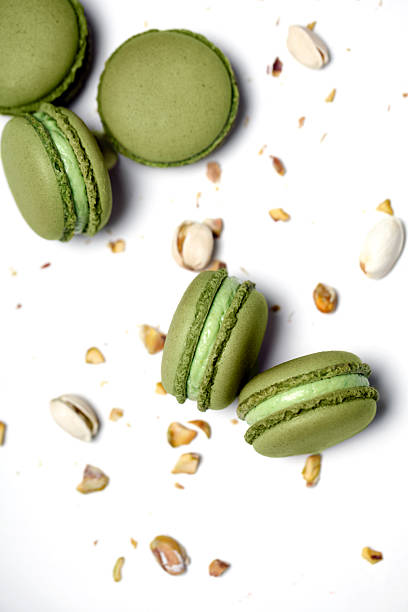 Delicious green pistachio macarons with scattered pistachio nuts