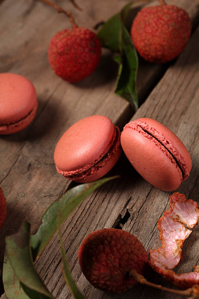 istock Delicious pink macarons with fresh lychees on wooden background 2244400076