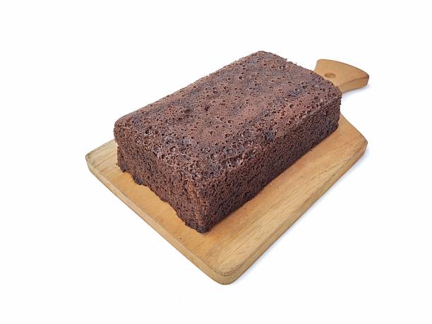 Chocolate brownies cake on wooden chopping board isolated on white background. High angle view
