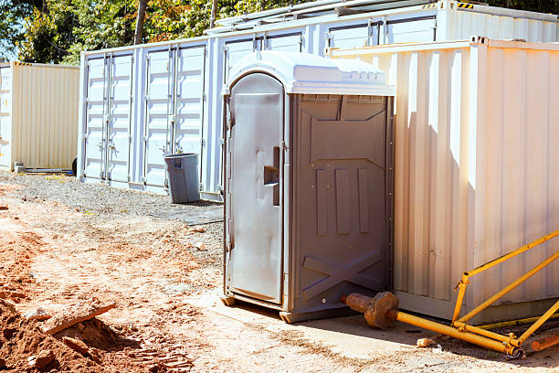 istock Portable restroom set up beside shipping containers at construction site 2244405157