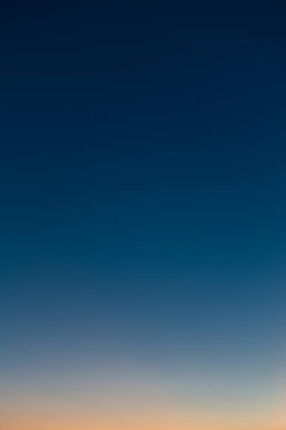 istock Vertical photo of a beautiful clear evening sky without clouds. Sky gradient from orange to dark blue. 2244406907