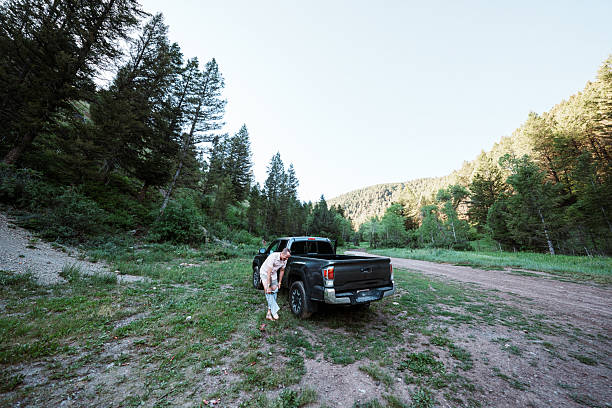 istock Ultra Runner Changes into Fresh Clothes at Trailhead After Morning Run in the Mountains 2244408906