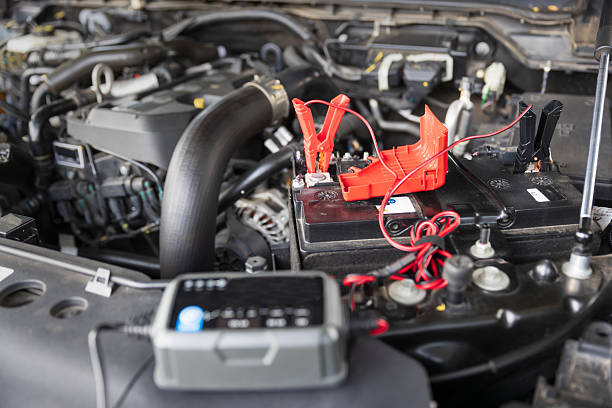 istock Man is charge a car AGM battery with a portable charger. 2244409355