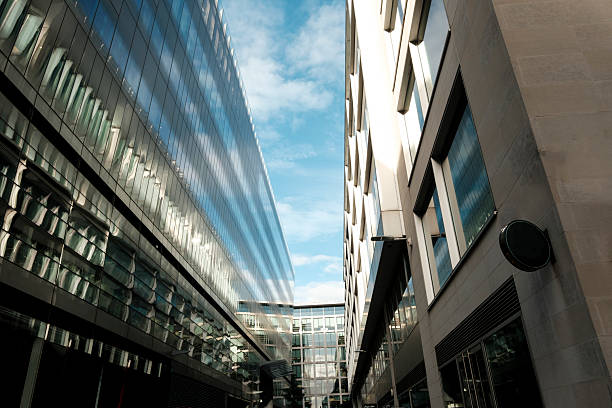istock Modern office buildings reflecting blue sky and clouds in an urban setting 2244412408